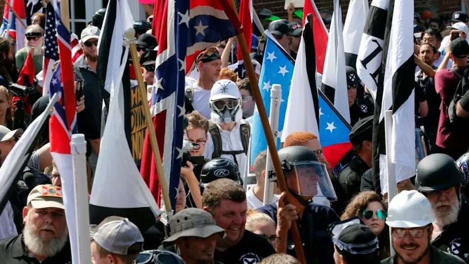 White nationalist demonstrators walk into the entrance of Lee Park in Charlottesville, Virginia on Aug. 12, 2017 surrounded by counter demonstrators. A jury on Monday ordered white nationalist leaders and organizations to pay a total of more than $26 million in damages to people who had suffered physical or emotional injuries during the event. (Photo: Steve Helber/AP, file)
